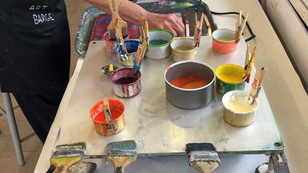 Paint, brushes, and cans on a table.