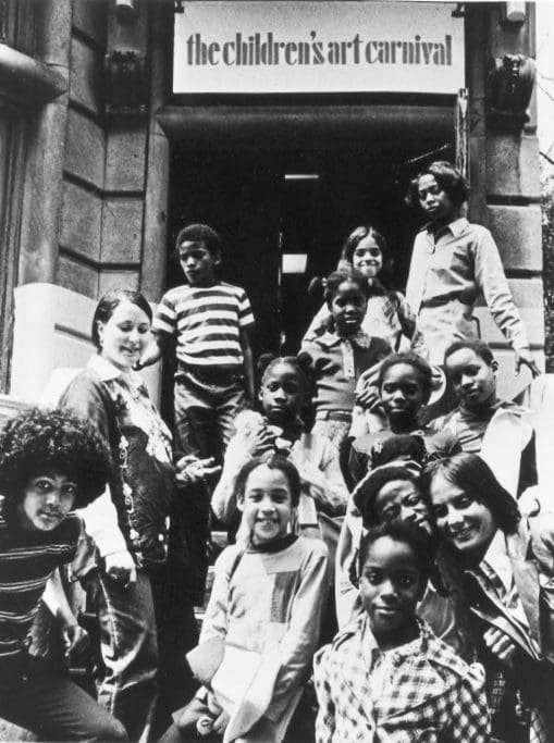 Children pose for photo outside art carnival.