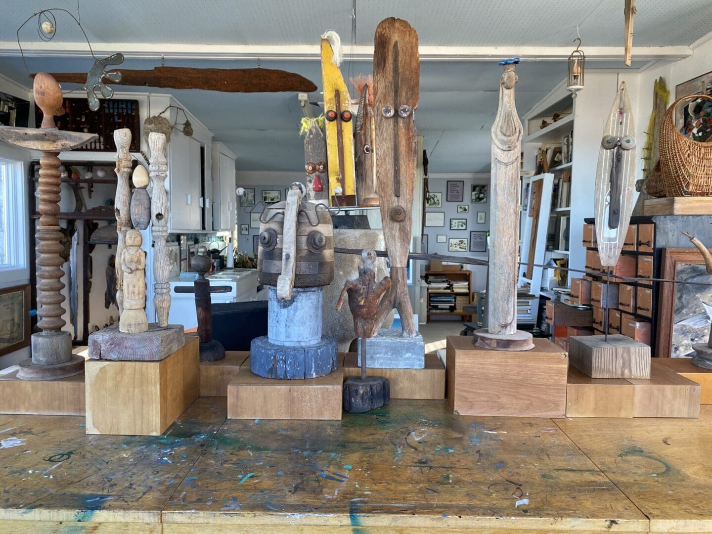 Wooden sculptures on a table in a studio.