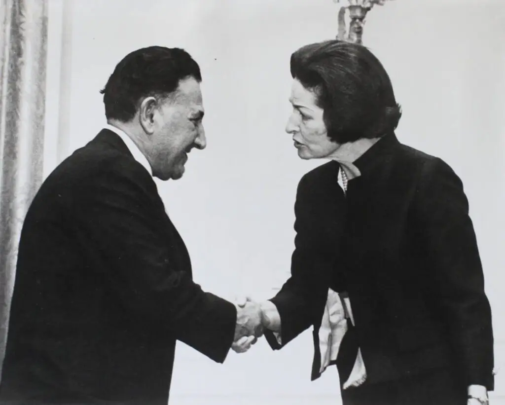 Black and white photo of two people shaking hands.