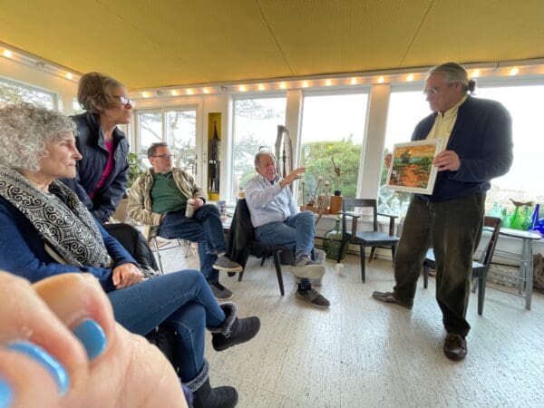 Group discussing art in sunroom.