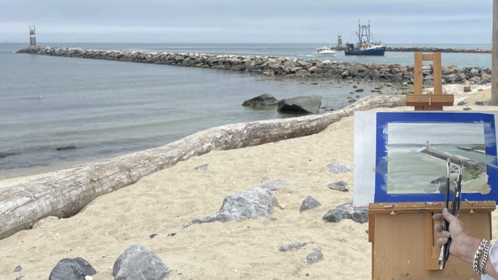 Beach scene painting on easel.