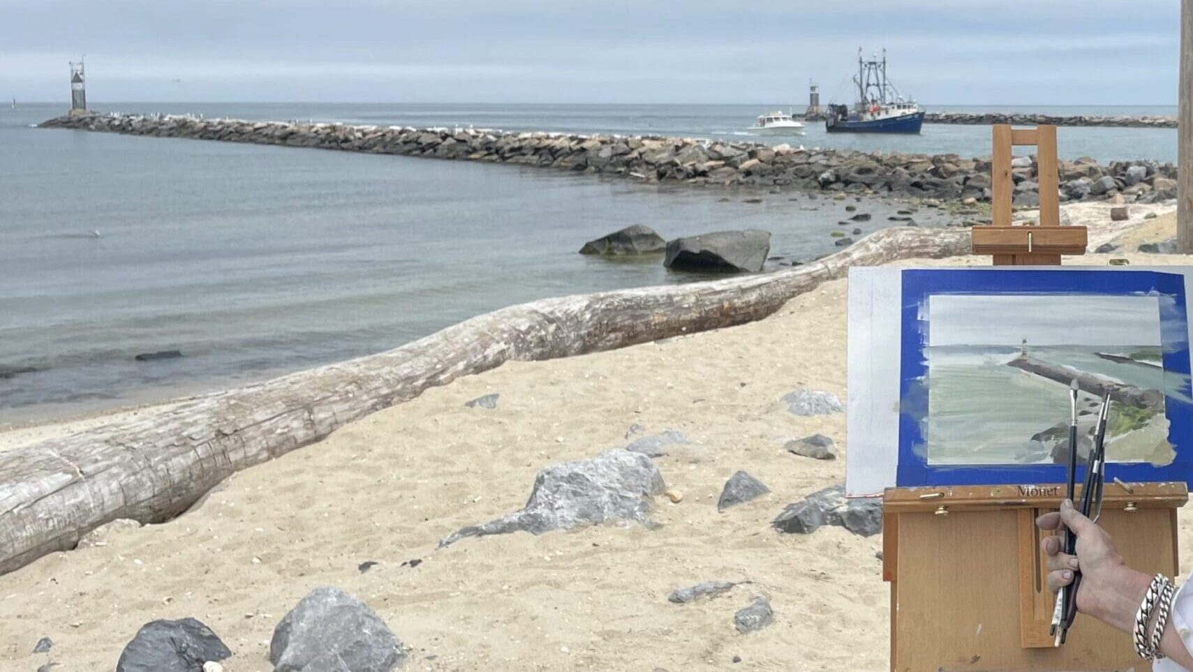 Beach scene painting on easel.