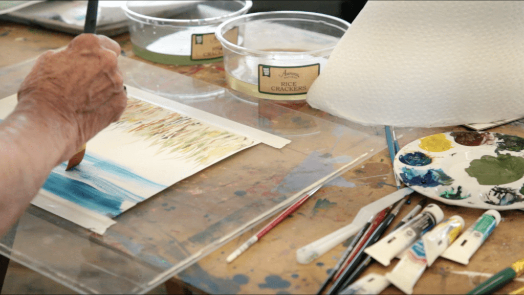 Artist's hand painting watercolor landscape.